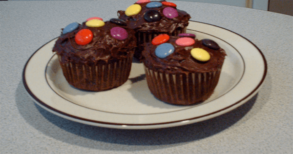 3 chocolate cupcakes iced and decorated with Smarties used as a header image