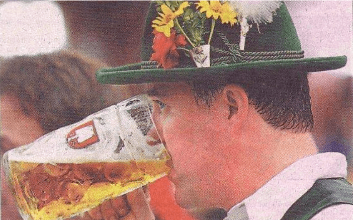 picture of a newspaper picture of a man drinking what looks like a pint of beer in a glass mug