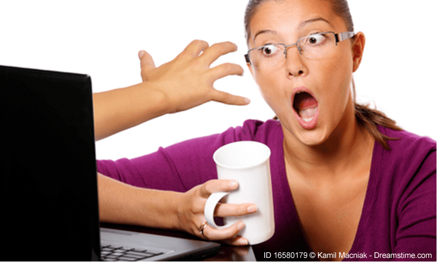 Lady sitting in front of a monitor with coffee cup, shocked look on her face as hand comes out of monitor at her - used as header image