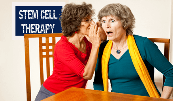 one lady is whispering into another lady's ear, shocking her with whatever is being said. Sign behind states "Stem Cell Therapy".